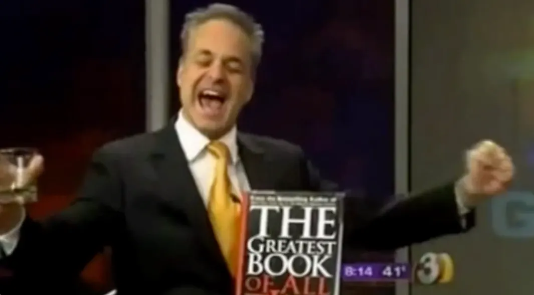 Person celebrating with a book in hand